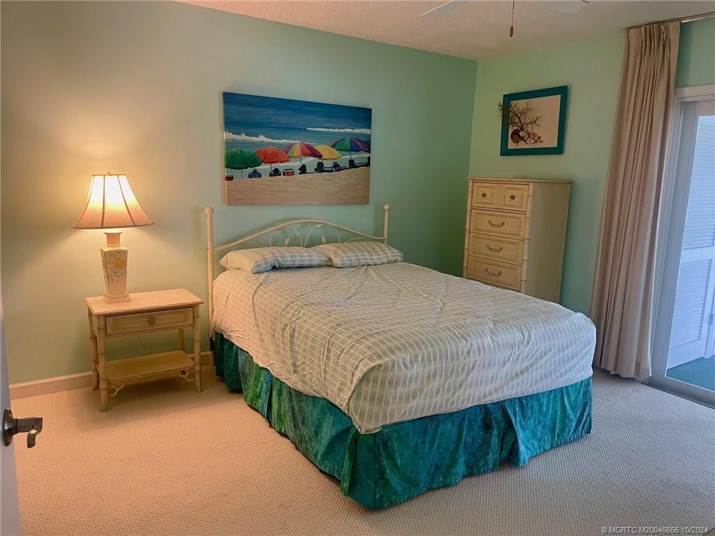 1225 Northwest 21st Street, Unit 3014 Stuart, FL 34994 - Photo 18 of 37 a bedroom with a bed and a night stand