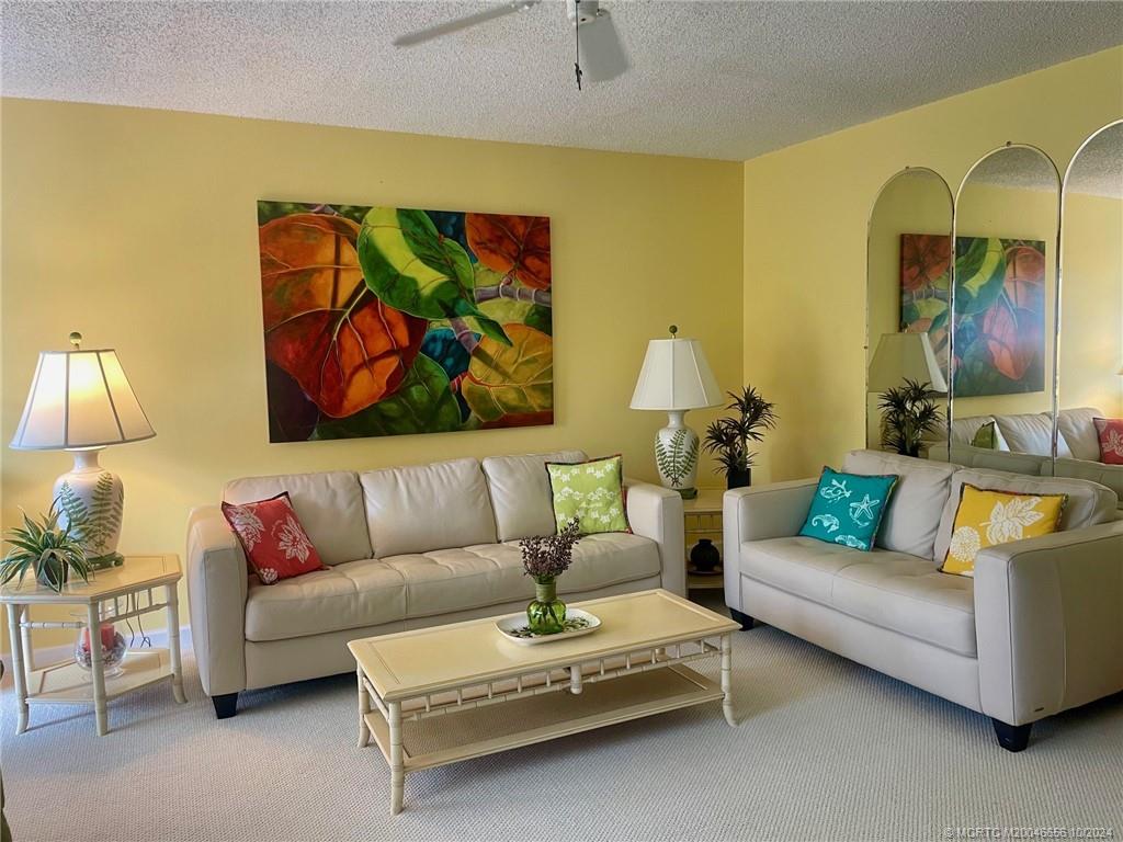 1225 Northwest 21st Street, Unit 3014 Stuart, FL 34994 - Photo 7 of 37 a living room with furniture a couch and painting on the wall
