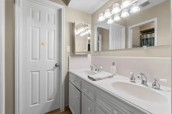 a bathroom with a double vanity sink and a mirror
