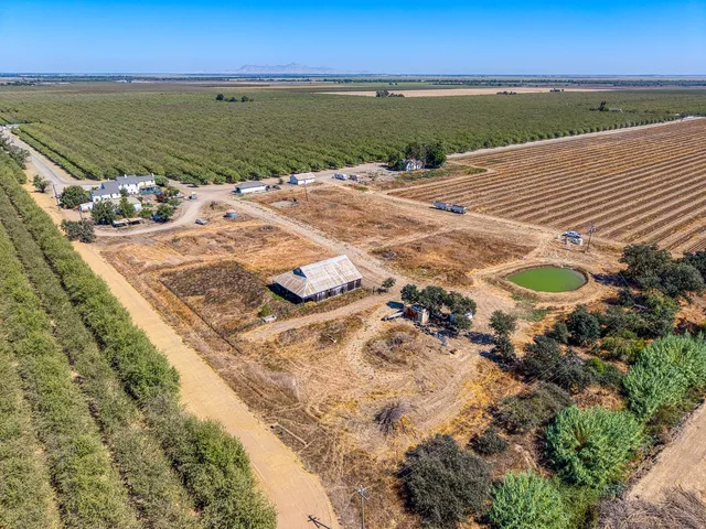an aerial view of a house with a yard and lake view
