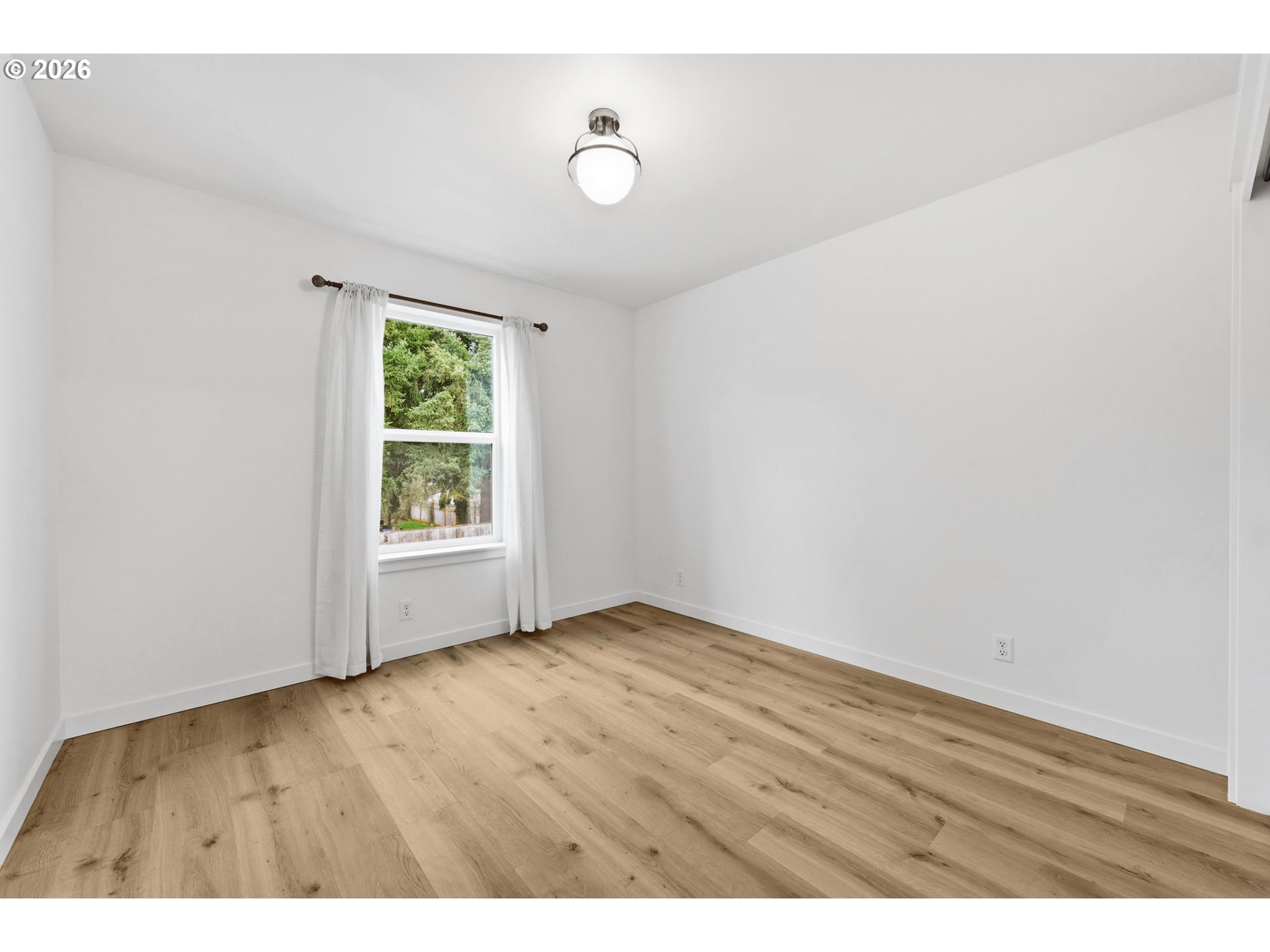 5592 Burnett Avenue, Unit B Eugene, OR 97402 - Photo 22 of 36 a view of an empty room with wooden floor and a window