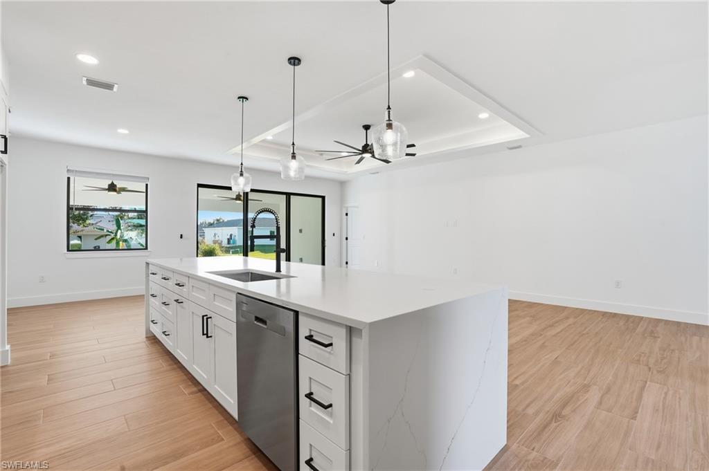 3903 15th Street Southwest Lehigh Acres, FL 33976 - Photo 13 of 44 a large kitchen with a large window a island a stove and wooden floor