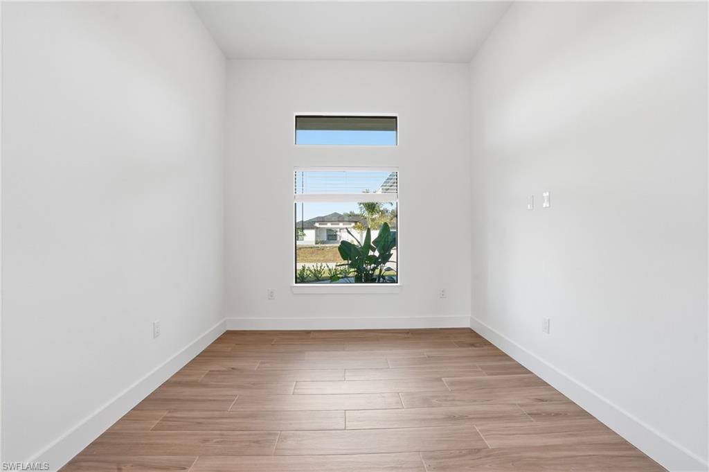 3903 15th Street Southwest Lehigh Acres, FL 33976 - Photo 14 of 44 an empty room with wooden floor and window