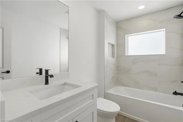 a bathroom with a sink a toilet and bathtub