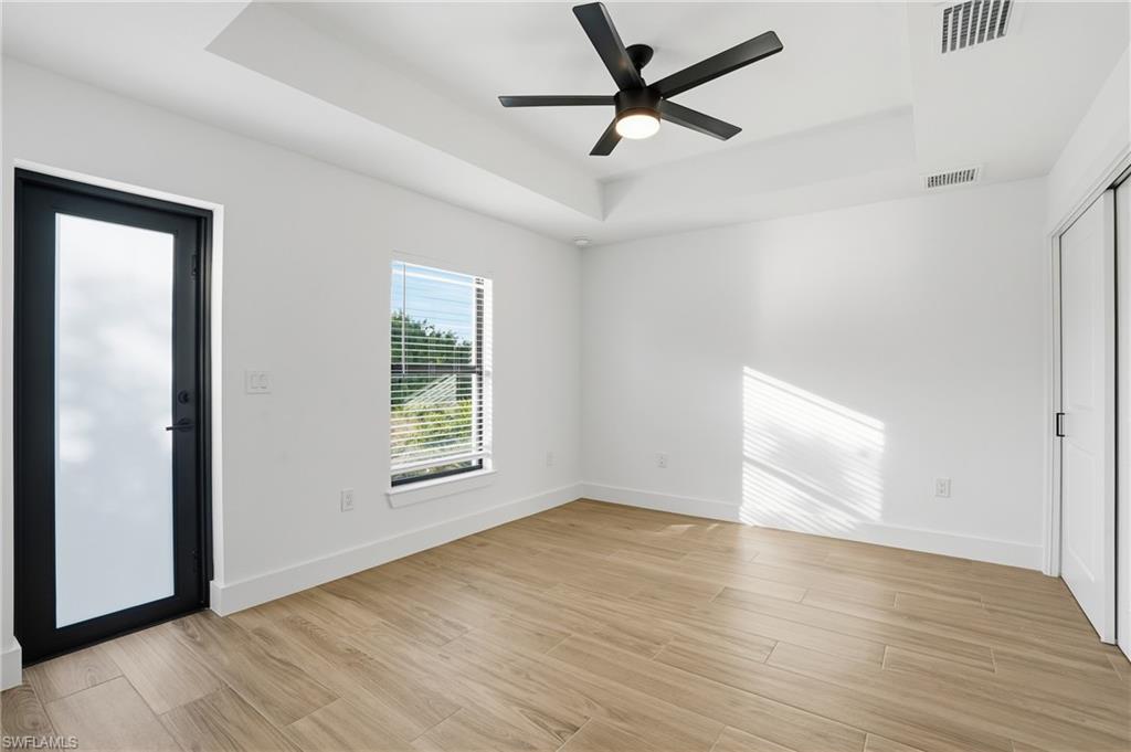 3903 15th Street Southwest Lehigh Acres, FL 33976 - Photo 28 of 44 wooden floor in an empty room with a window