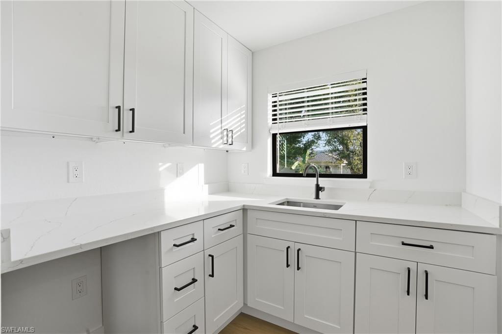 3903 15th Street Southwest Lehigh Acres, FL 33976 - Photo 31 of 44 a kitchen with white cabinets and a window