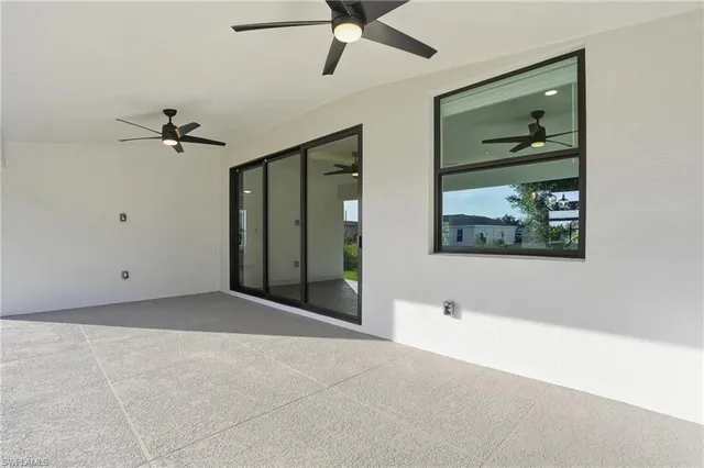 a view of a hallway with wooden floor and a chandelier fan