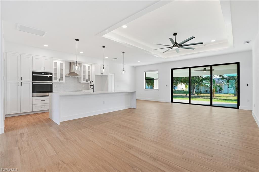 3903 15th Street Southwest Lehigh Acres, FL 33976 - Photo 8 of 44 a view of an empty room with kitchen view and wooden floor