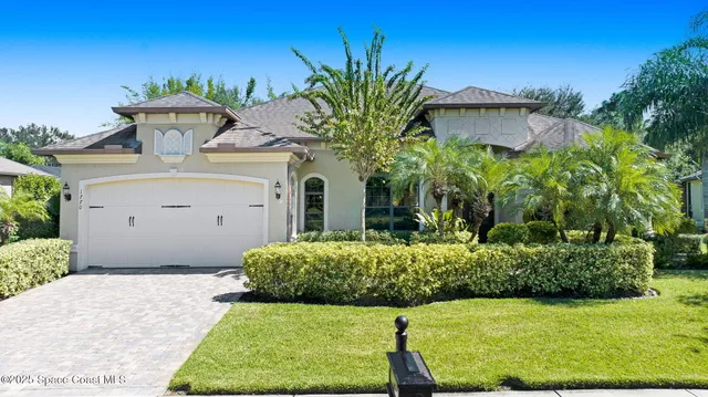 a view of a white house with a yard and potted plants