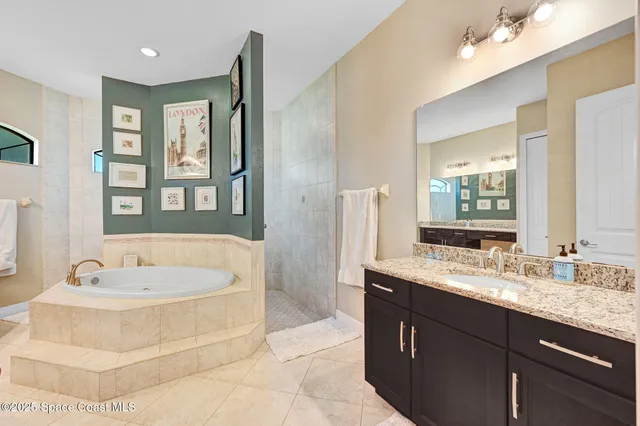 a spacious bathroom with a bathtub a double vanity sink and a mirror