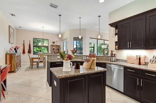 a kitchen with granite countertop a sink dishwasher stove and cabinets