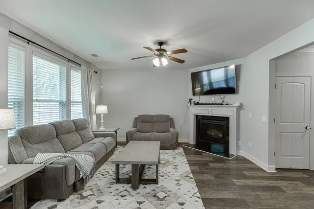 a living room with furniture a fireplace and a flat screen tv