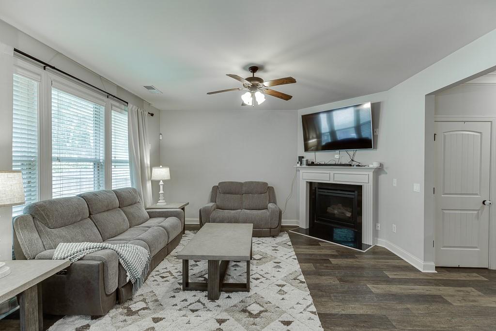 2140 Harvest Ridge Circle Northeast Buford, GA 30519 - Photo 12 of 38 a living room with furniture a fireplace and a flat screen tv