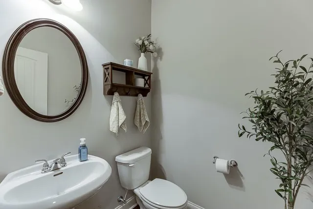 a bathroom with a toilet sink and mirror