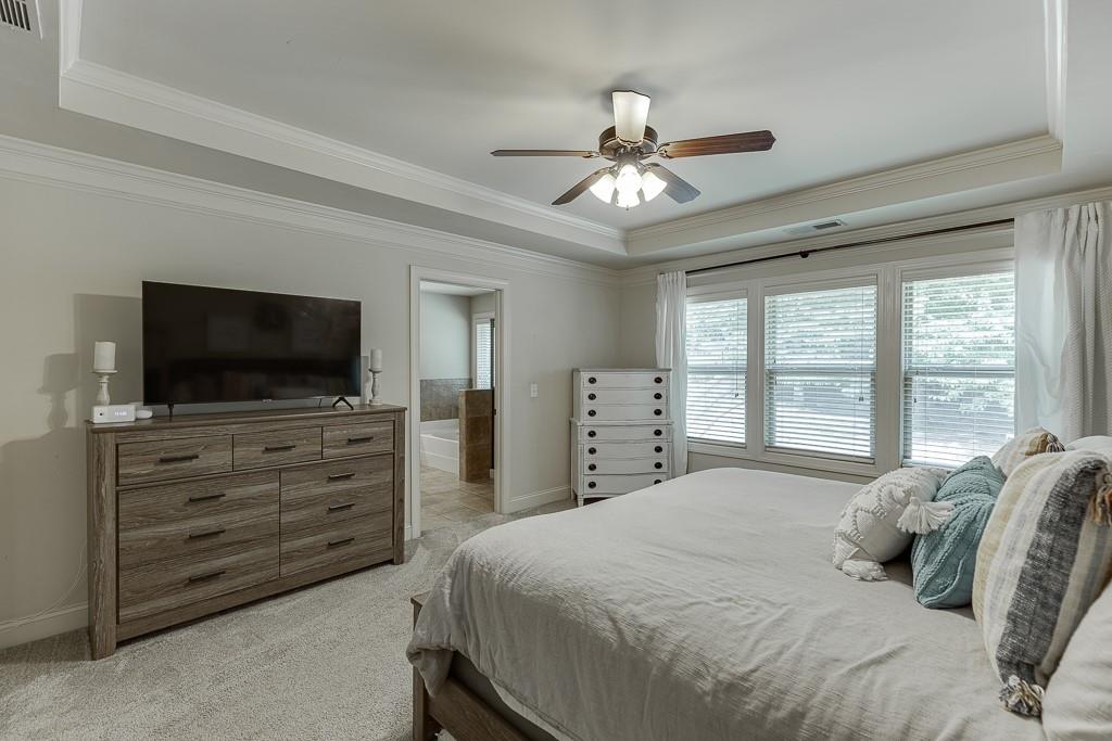 2140 Harvest Ridge Circle Northeast Buford, GA 30519 - Photo 22 of 38 a bedroom with a large bed and a flat screen tv