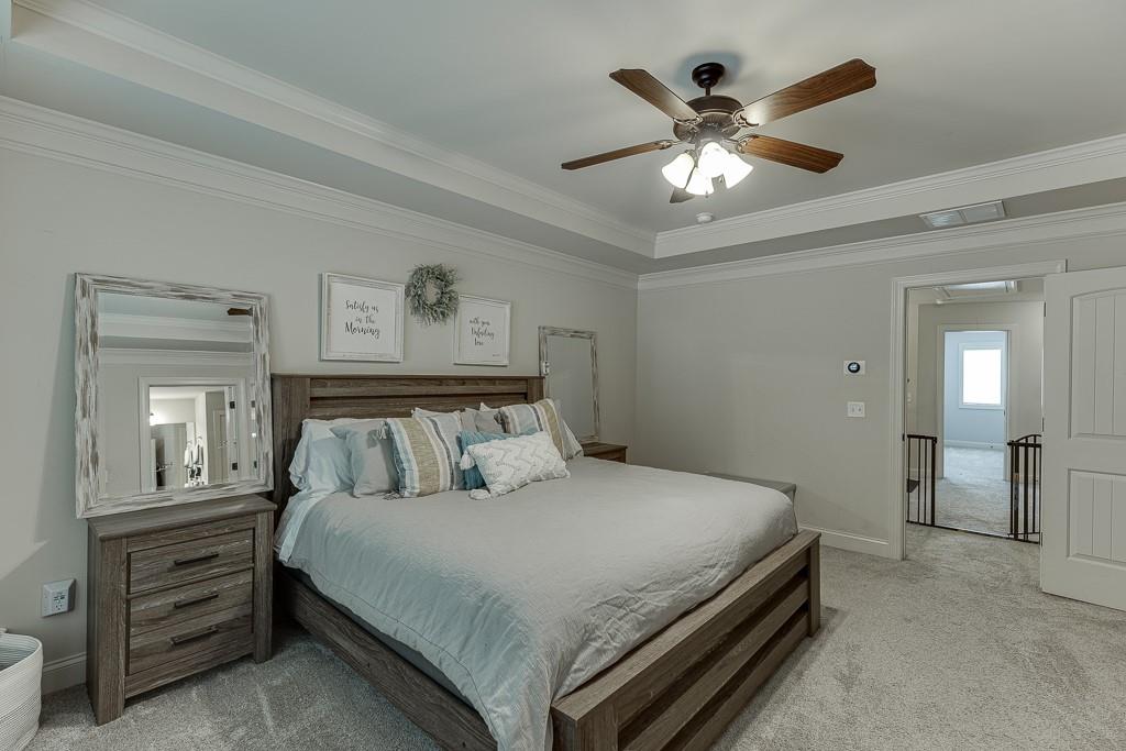 2140 Harvest Ridge Circle Northeast Buford, GA 30519 - Photo 24 of 38 a spacious bedroom with a bed and a chandelier