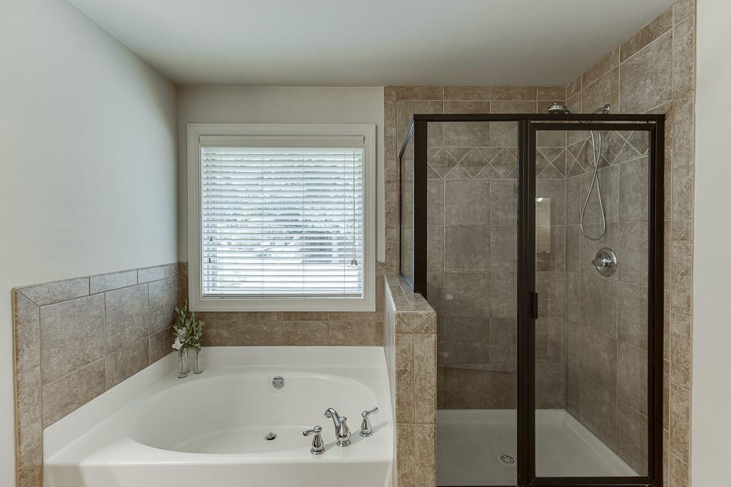 2140 Harvest Ridge Circle Northeast Buford, GA 30519 - Photo 26 of 38 a bathroom with a bathtub and a shower