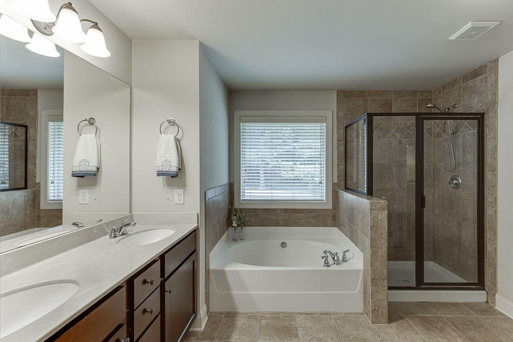 2140 Harvest Ridge Circle Northeast Buford, GA 30519 - Photo 27 of 38 a bathroom with a tub a sink shower and mirror