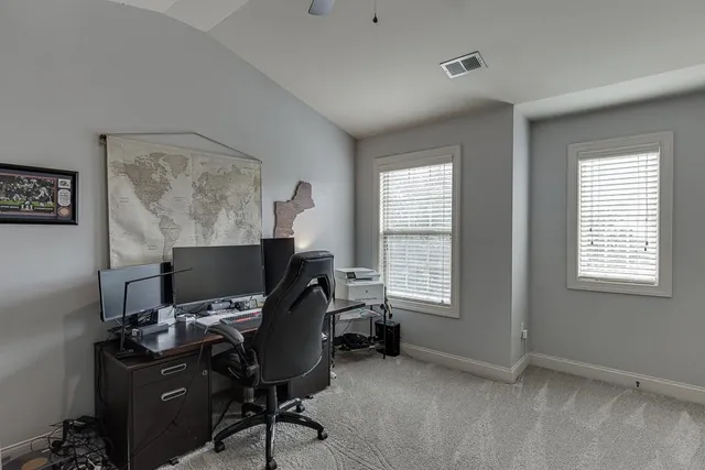 a view of a workspace with furniture and a window