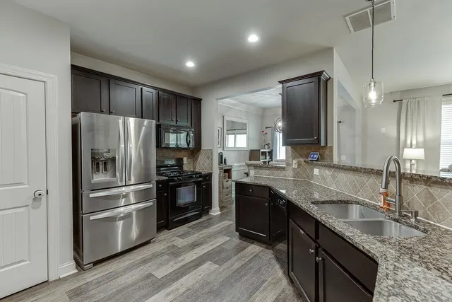 a kitchen with stainless steel appliances granite countertop a sink stove and refrigerator