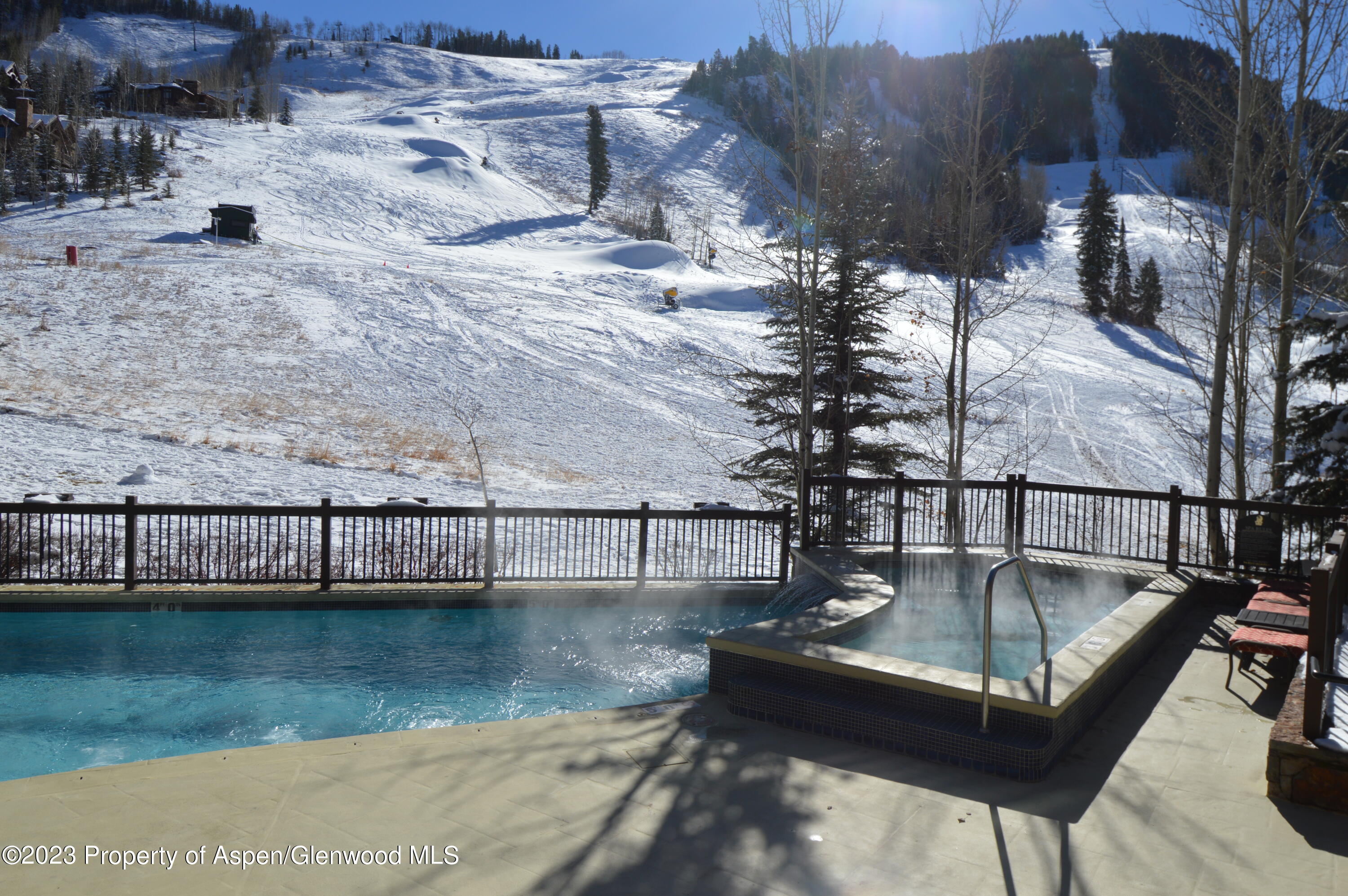 197 Prospector Road, Unit 2405 SUMMER INTEREST 12 Aspen, CO 81611 - Photo 16 of 24 a view of swimming pool with a table and chairs
