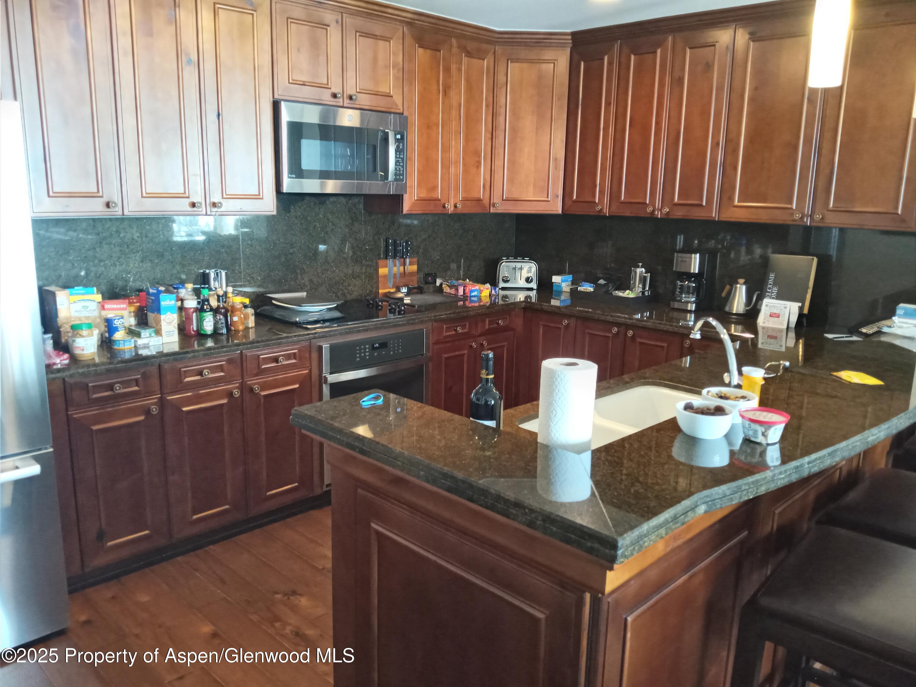 197 Prospector Road, Unit 2405 SUMMER INTEREST 12 Aspen, CO 81611 - Photo 23 of 24 a kitchen with a sink a stove and cabinets