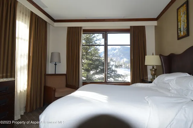 a bedroom with a bed and a large window