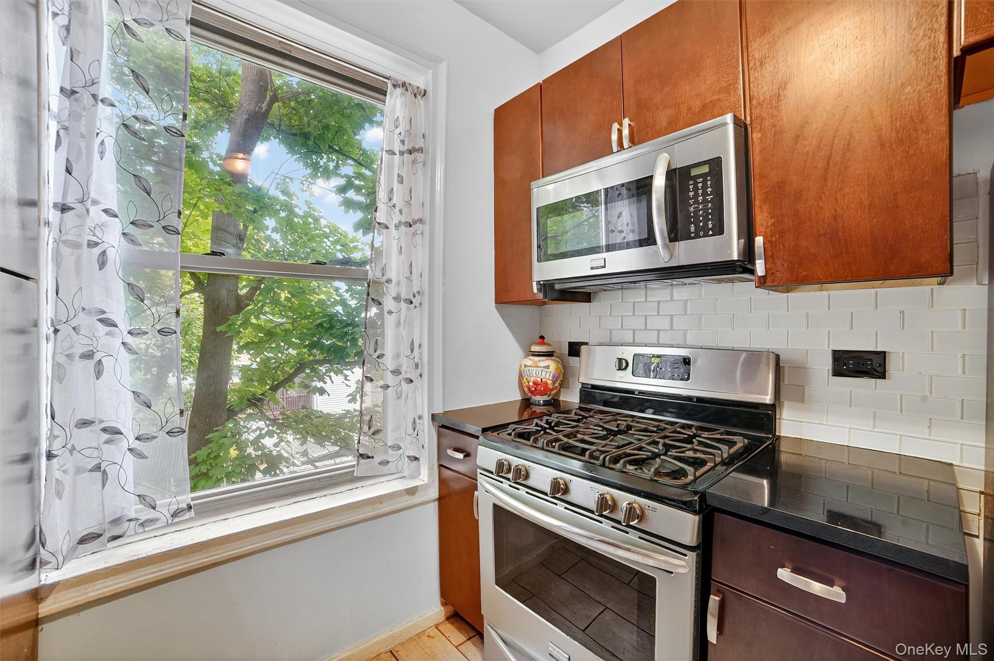 219 Bronx River Road, Unit 2L Yonkers, NY 10704 - Photo 16 of 29 a kitchen with stainless steel appliances white cabinets and a stove top oven