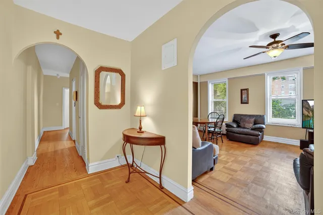 a living room with furniture kitchen view and a window