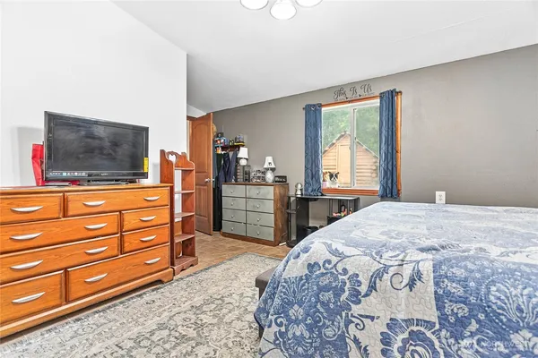 a bedroom with a bed and a flat screen tv