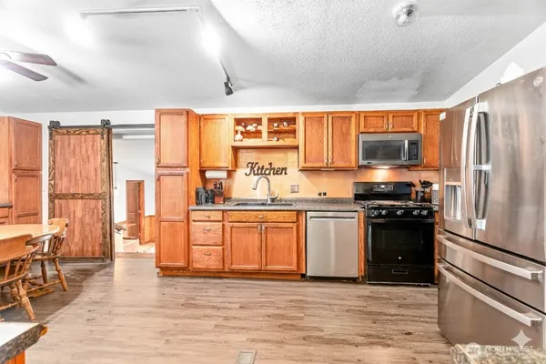 a kitchen with stainless steel appliances granite countertop a refrigerator stove and sink