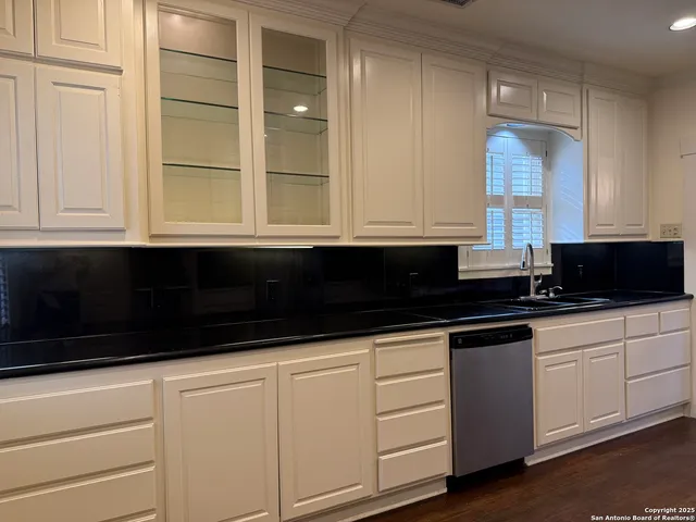 a kitchen with granite countertop white cabinets and sink