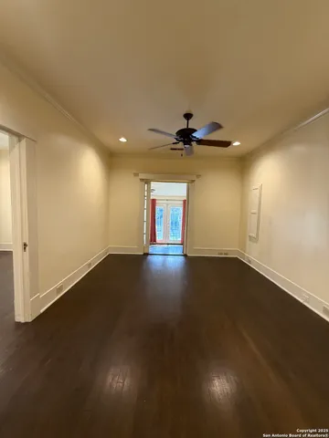 a view of empty room with wooden floor