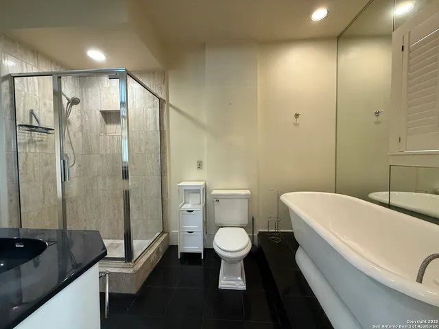 a bathroom with a sink a toilet a tub and shower