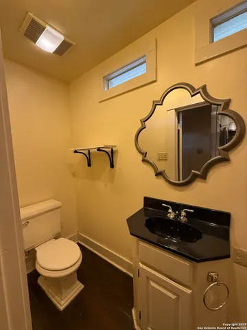 a bathroom with a toilet a sink and mirror