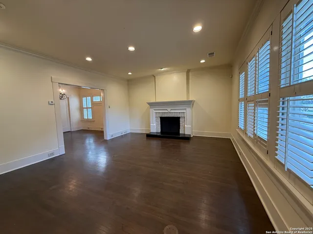 a view of empty room with wooden floor and fireplace