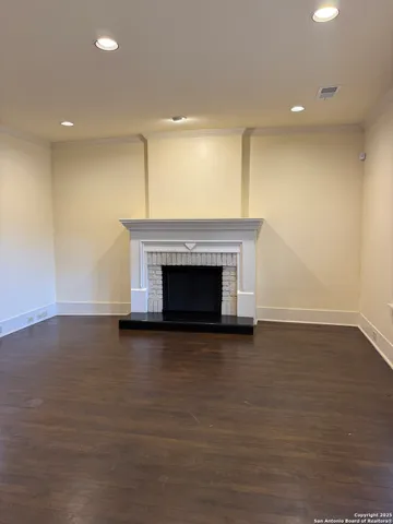 a view of empty room with wooden floor and fireplace