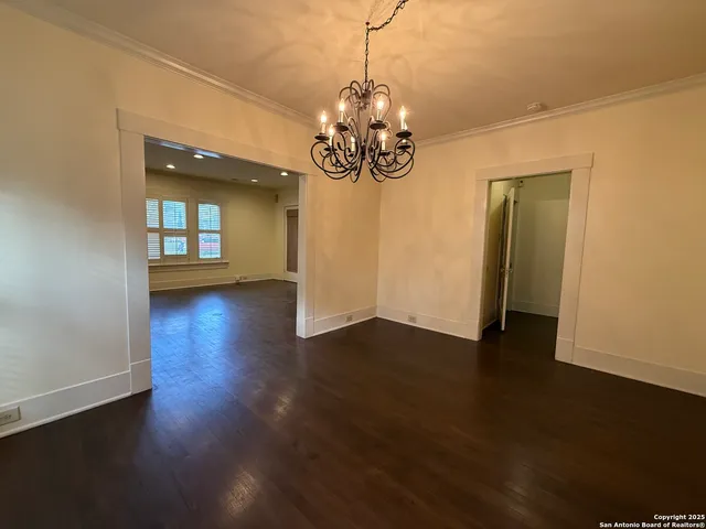 a view of a room with wooden floor and chandelier