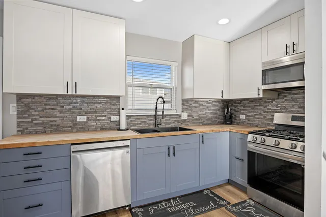 a kitchen with stainless steel appliances granite countertop a sink stove and cabinets