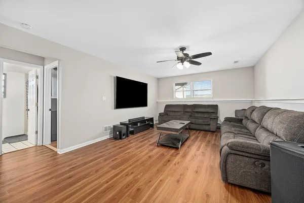 a living room with furniture ceiling fan and a flat screen tv
