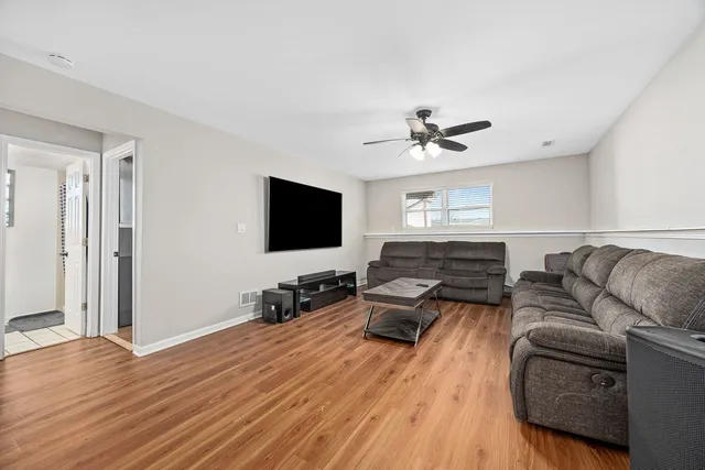 a living room with furniture ceiling fan and a flat screen tv