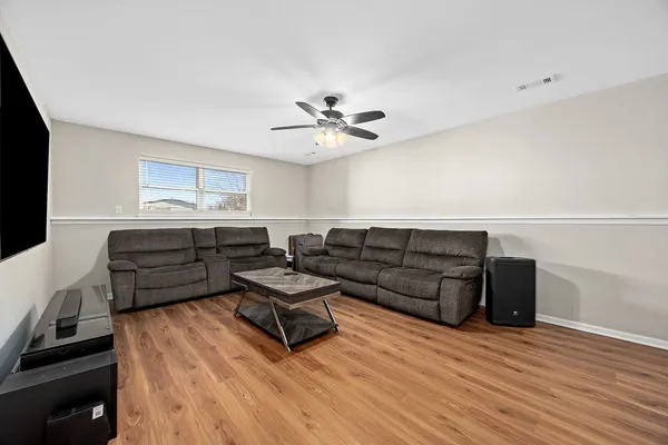 a living room with couches and furniture with wooden floor