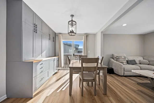 a kitchen with granite countertop lots of white furniture wooden floor and stainless steel appliances