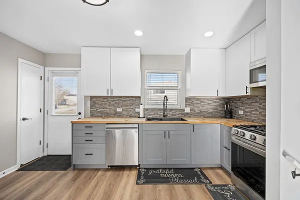 a kitchen with granite countertop a stove sink and cabinets
