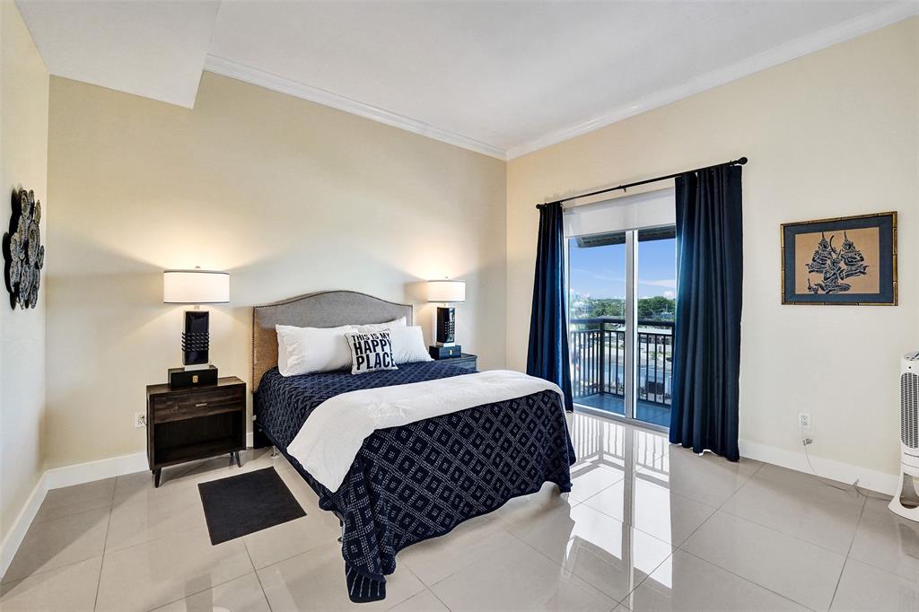 2617 Northeast 14th Avenue, Unit 507 Wilton Manors, FL 33334 - Photo 16 of 65 a bedroom with a bed and a large window