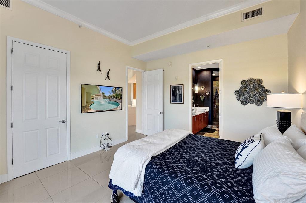 2617 Northeast 14th Avenue, Unit 507 Wilton Manors, FL 33334 - Photo 17 of 65 a bedroom with a bed and a lamp on dresser