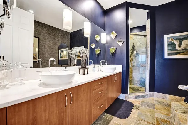 a bathroom with a sink a bathtub and a painting on the wall