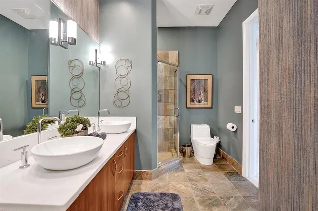 a bathroom with a sink a toilet and shower