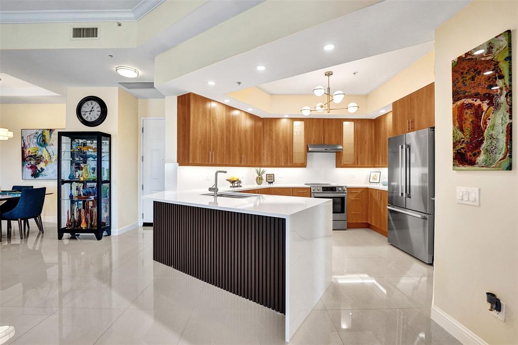2617 Northeast 14th Avenue, Unit 507 Wilton Manors, FL 33334 - Photo 10 of 65 a large kitchen with a large counter top a sink stainless steel appliances and cabinets