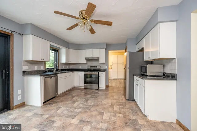 a kitchen with granite countertop a stove sink and cabinets